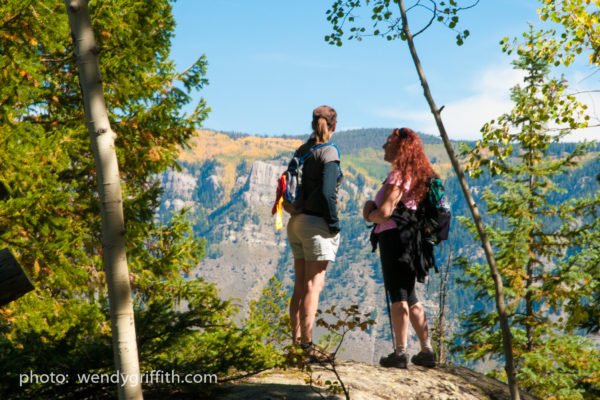 two women hiking near an overlook in the rocky mountains