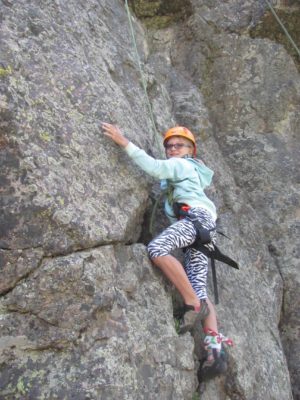 young girl climbing rock face at chrysalis circle retreat, women's empowerment workshop