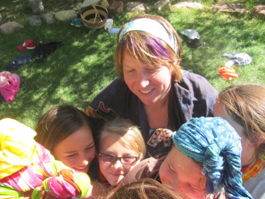 young girls hugging in a group, summer camp, women's empowerment workshop