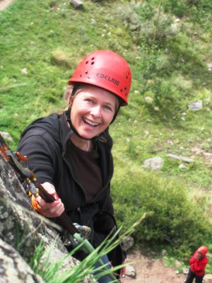 woman rock climbing and repelling down rock face in colorado, women's empowerment workshop