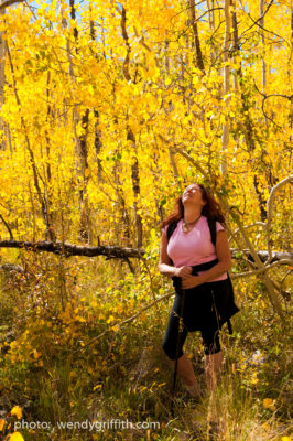 woman hiking in golden aspen trees near vail colorado, reflecting on self